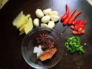 家常菜焖猪脚,准备好所有材料,生姜切片,大蒜剥好就行了,葱花,小辣椒两个切成小圈,其余三个小辣椒中间划上一刀就好了,整个的辣椒是炒的时候放的,辣椒圈是出锅放的(不吃辣的可以不加辣椒)