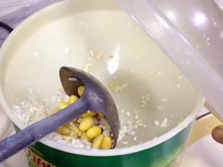 福建小吃—油饼,把混合好的黄豆、大米和水分次慢慢加入到磨浆机内研磨。