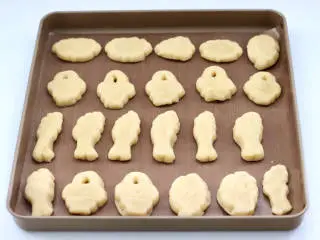 胶东节日小吃~七夕巧果,做好的巧果生胚脱模,依次做完所有的剂子,把做好的巧果生胚,放入铺入油纸的烤盘上。