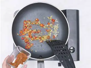 香煎红鱼佐泰式风味酱汁,锅不用洗,倒入10毫升橄榄油 ,小火煎炒九层塔末、姜末、红杭椒圈、香茅末大约30秒后,加入泰式红咖喱酱 炒匀。 加入鱼露 ,倒入60毫升水。开小火把煎好的红鱼放进锅中,加盖煮30秒后翻面继续煎30秒后盛出红鱼。红鱼放入盘中,淋上汤汁,撒上之前留下的九层塔大叶做装饰即可。