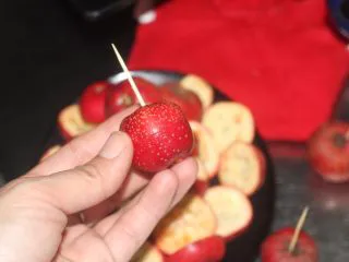 老北京小吃之冰糖葫芦,处理好一个山楂就用牙签穿起来,免得都切开挖籽扔乱了找不到配套的山楂,有竹签就更好了可以直接穿成串。