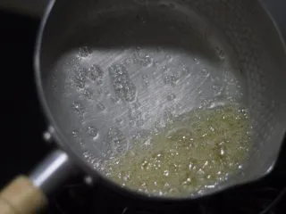 老北京小吃之冰糖葫芦,注意!随着时间的推移,糖水里水份蒸发,均匀受热状态下糖浆会先变成这种浅黄色,这个时候要打起精神,一定看好了不要过火,变成深褐色就是糊了,得扔。只要通晓熬糖的原理,我们常见的拔丝山药之类的菜也可以搞定。像这个状态再熬个半分钟糖泡变成芝麻大小就可以做拔丝。