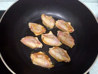 新奥尔良风味砂锅翅,鸡翅从冰箱取出，逐只翻个个儿，放至室温，入煎锅小火两面煎一下，不要煎太焦。腌鸡翅的盘子里剩下的调料不要倒掉。