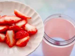 车厘子草莓冰奶昔,把切半的草莓,也放入果汁机里。