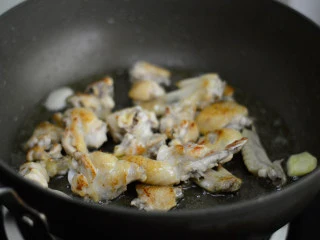 酱烧土豆鸡翅,煎至两面焦黄后放入姜蒜，翻炒出香味 