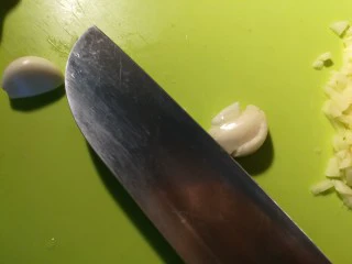 北京传统经典小吃-老北京麻豆腐,蒜用刀按住，用手掌用力拍下刀，蒜就碎了，不用担心蒜会拍飞啦！