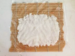 上班族的便当 风味独特的粢饭团,取2大勺米饭放在保鲜膜上铺平