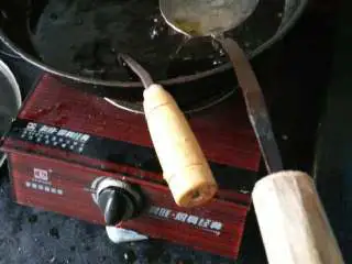 松阳特色小吃灯盏盘,锅内加入油烧得滚烫，放入灯盏盘底座勺，用油炸得滚烫。