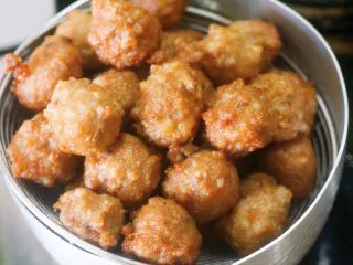 老北京小吃之“干炸小丸子”,第一遍高温油炸定型的丸子捞出来放一旁控油降温,只有等丸子凉一点了,第二遍炸才不容易糊。