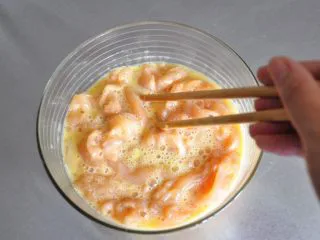 街头小吃自己做---香酥无骨鸡柳,将鸡肉倒入蛋液中,表面均匀的裹上蛋液。