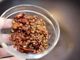 正宗地道的麻婆豆腐,把干辣椒和辣椒盛出来扔掉，避免影响口感。锅中只留炒完花椒辣椒的油。
