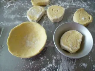 多图详解街头人气美食~~~葡式蛋挞,每个蛋挞模涂抹少许奶油放粘。