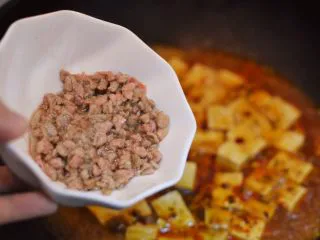 正宗地道的麻婆豆腐,煮开后放入牛肉末、生抽、黑胡椒粉和白糖少许。调小火，盖上锅盖。（中间可以打开锅盖，用铲子轻推防止粘锅）