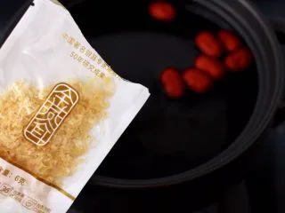 金燕耳金桔桂圆羹,撕开金燕耳的外包装倒入砂锅中。