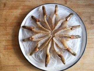 蒜蓉粉丝开背虾,将开好背的虾均匀在粉丝上铺开。