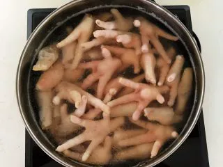 私房菜 密制酸辣鸡爪,锅里加入冷水,放入鸡爪,水开后煮2分钟