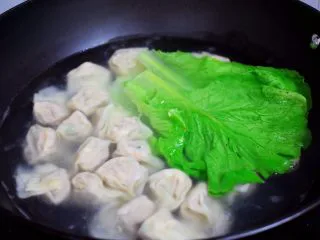 鲜虾猪肉馄饨,锅中倒入适量的清水烧开后，放入馄饨和生菜
