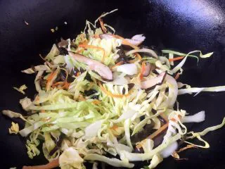 天津特色小吃 蔬菜烩饼,放入香菇、木耳、圆白菜,炒匀。