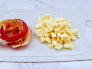 苹果蔓越莓奶昔,洗净的苹果去皮后，用刀切成小丁。