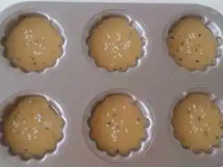 中国风咸味玛德琳,5.把面糊分放入玛德琳模并在表面洒上芝麻,八九分满即可,静置15分钟.入烤箱中层,210度上下火先烤4分钟,然后降温至180度再烤8分钟即可.