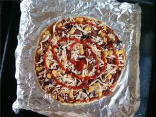 烟熏风味BBQ烤鸡肉披萨,撒上剩余分量的芝士碎，零散地挤上番茄酱。表面撒上一点现磨粗粒黑胡椒和干牛至碎。