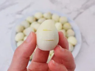 香辣啤酒鹌鹑蛋,然后在鹌鹑蛋表面划两刀,这样煮的时候更入味