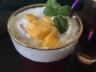 多肉葡萄汁儿,筛入抹茶粉，加芒果粒和薄荷叶装饰。