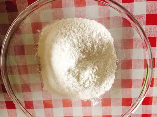 北京小吃·驴打滚,准备好糯米粉，慢慢分次加入清水。 注：糯米粉比较不吸水，而且牌子不同吸水性也不同，因此水的份量根据面团状态而定，和成团不干即可。 