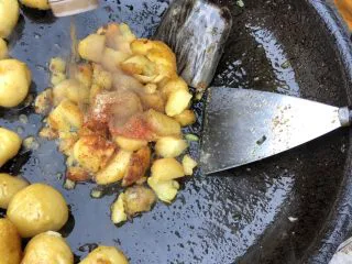 巫山特色小吃-炕洋芋,倒入适量孜然粉