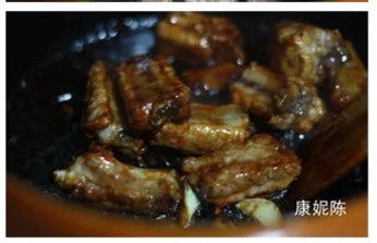 田园风味【南瓜烧排骨】,放入料酒、红烧酱油和冰糖，将调料和排骨炒匀
