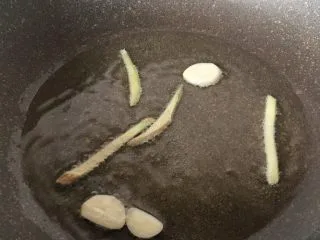 下饭菜香菇榨菜炒肉丝,姜丝和蒜头放油锅炒香后捞出