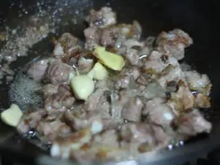 蔓越莓烧排骨,放入冰糖和姜蒜,翻炒至冰糖融化