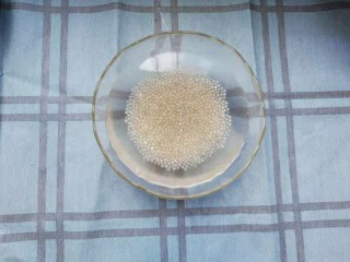 手煮奶茶西米露,西米煮到半透明,中间还有一点儿白色硬芯儿的时候关火,过滤出水,倒入冰水中投几遍。