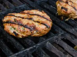 越南风味牛油果火鸡堡,烤架预热到220度后，放入肉饼，每面烤5分钟，最后一分钟在每片肉饼上放美国芝士 ，烤至刚好融化。