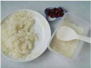 北京小吃:切糕,取出蒸制好的糯米饭和红枣,找个保鲜盒,将糯米饭沾水揉匀,并用铲子按成薄厚相当的层片。