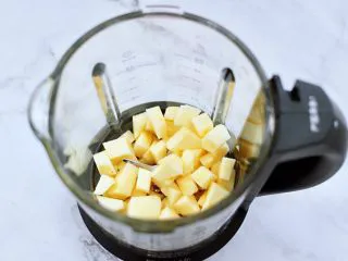 苹果蔓越莓奶昔,把切丁的苹果，放入破壁机里。