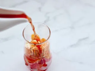 橘子蔓越莓蜂蜜冰饮,这个时候倒入蔓越莓果汁。