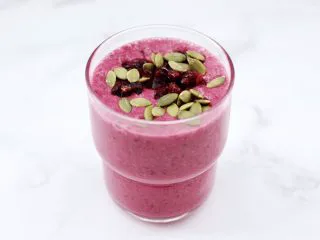 香蕉蔓越莓奶昔,上面铺上蔓越莓干和南瓜籽。