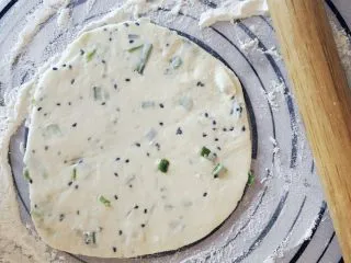 从小吃到大的黑芝麻葱油饼,按压面团，然后用擀面杖擀平。