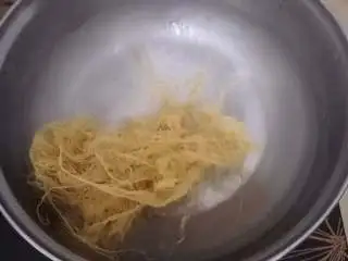 家乡小吃——狗毛膏鸽春丸,冰糖融化后放入狗毛膏草中大火煮