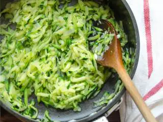 地中海风味火鸡肉丸,用高火加热另一半橄榄油 ，放进擦碎的中号西葫芦 ，炒5分钟，到西葫芦变软后，撒盐。