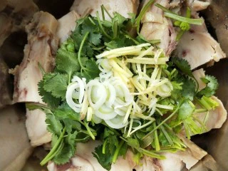 花雕酒焗藤椒手撕鸡,把香菜段,姜丝,葱丝放鸡块上。