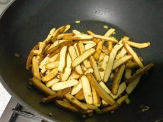 家常小炒韭菜香干,继续翻炒，待香干外皮焦黄，此时盐和鸡精块已完全融化，吸附在香干上。