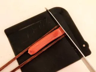 10分钟快手菜 肉粒多风味香肠炒俄式乳瓜,取一根小香肠，在香肠的两边各放一根筷子，把香肠切成连刀片