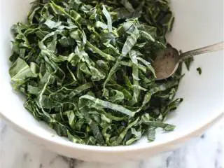 越南风味羽衣甘蓝大虾色拉,第三步:同时,在一个大号沙拉碗中,混合羽衣羽衣甘蓝 、青柠汁、鱼露和薄荷叶,至羽衣甘蓝均匀裹上调味料;加入脆炸椰油洋葱丝以及剩余的油,再拌一拌。