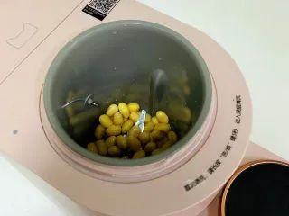胡萝卜枸杞豆浆,往九阳ksolo豆浆机内加入泡发好的黄豆。