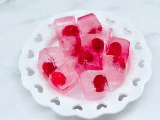 橘子蔓越莓蜂蜜冰饮,把冷冻好的蔓越莓果冰块取出脱模。