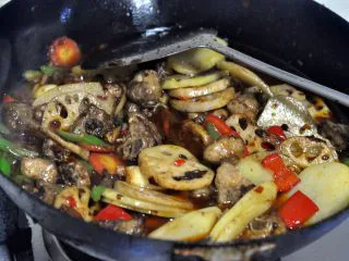 香辣干锅排骨,为了让排骨更好的进味，这时倒入一小碗水。