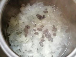 百变水果 苹果香橙银耳羹,砂锅内放水烧开，下入银耳和葡萄干再次烧开，转中小火煮40分钟。