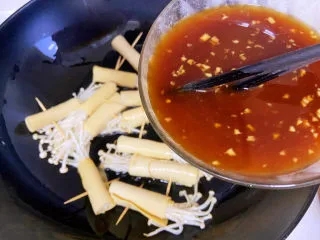 豆皮金针菇卷,酱汁再用筷子搅拌一下，然后倒入锅中。